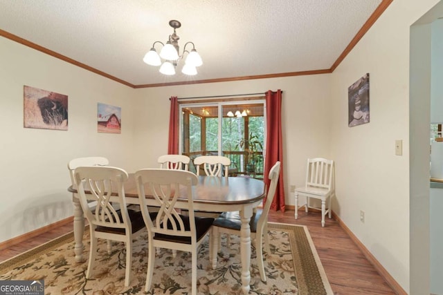 dining space with a notable chandelier, a textured ceiling, wood-type flooring, and crown molding