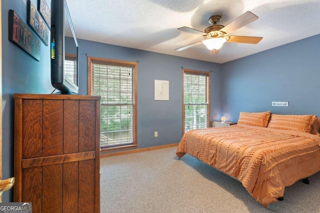 bedroom featuring ceiling fan, carpet flooring, and a textured ceiling