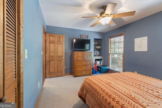 bedroom featuring ceiling fan, a textured ceiling, and light colored carpet