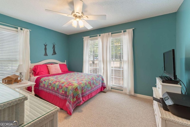 bedroom featuring a textured ceiling, carpet flooring, and ceiling fan