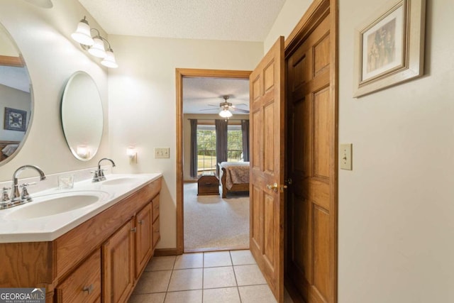 bathroom with vanity, a textured ceiling, ceiling fan, and tile patterned flooring