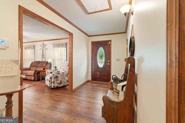 entrance foyer featuring a textured ceiling, ornamental molding, and hardwood / wood-style floors