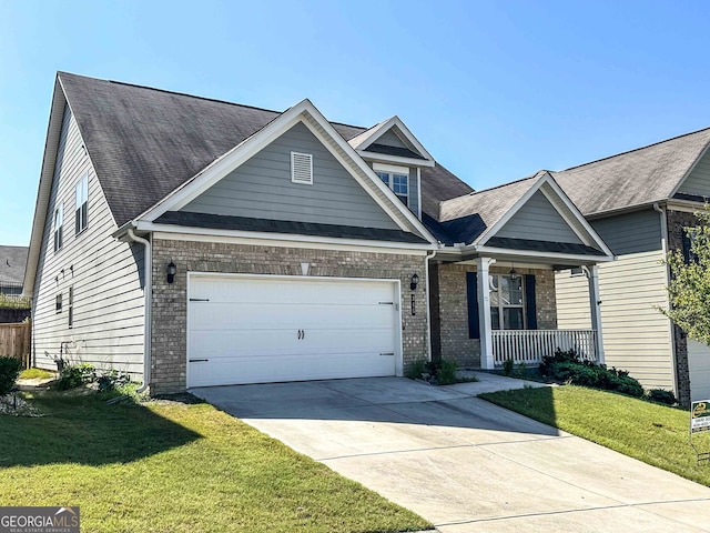 craftsman-style house with covered porch, a front yard, and a garage