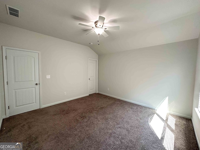 carpeted spare room featuring ceiling fan and vaulted ceiling