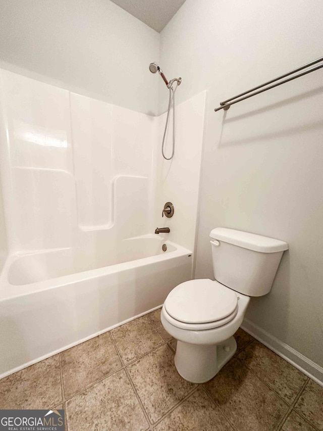 bathroom featuring shower / bathing tub combination, toilet, and tile patterned flooring