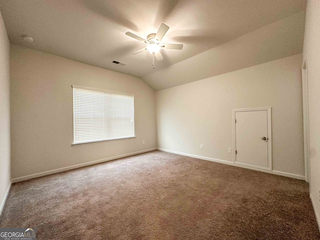 carpeted spare room featuring lofted ceiling and ceiling fan