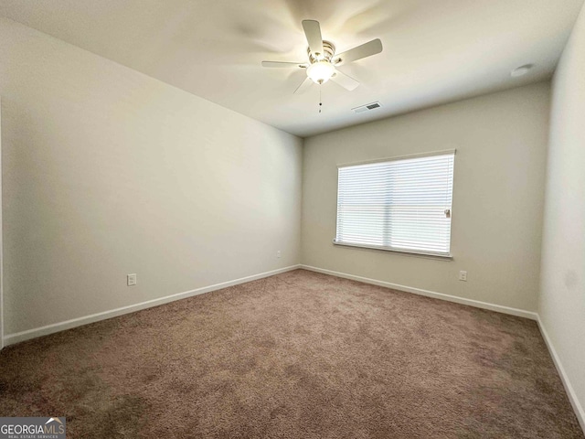 carpeted spare room featuring ceiling fan