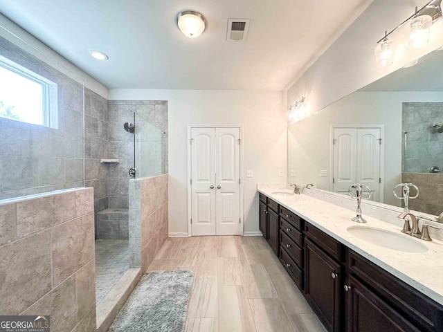 bathroom with vanity and a tile shower