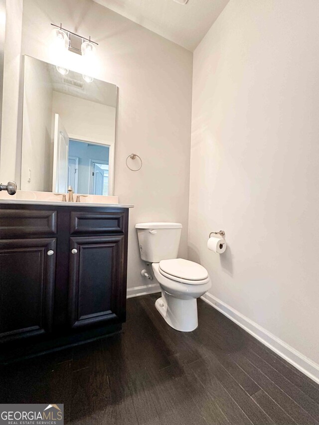 bathroom featuring vanity, toilet, and hardwood / wood-style floors