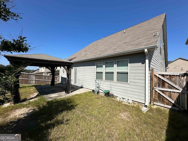 back of property with a gazebo, a lawn, and a patio area