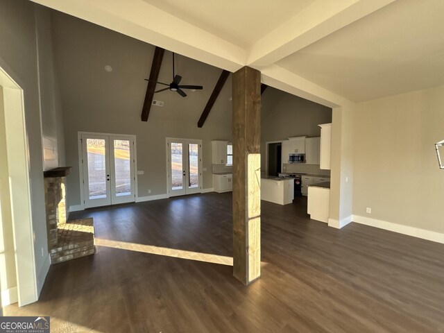 unfurnished living room with french doors, dark hardwood / wood-style flooring, ceiling fan, high vaulted ceiling, and beamed ceiling