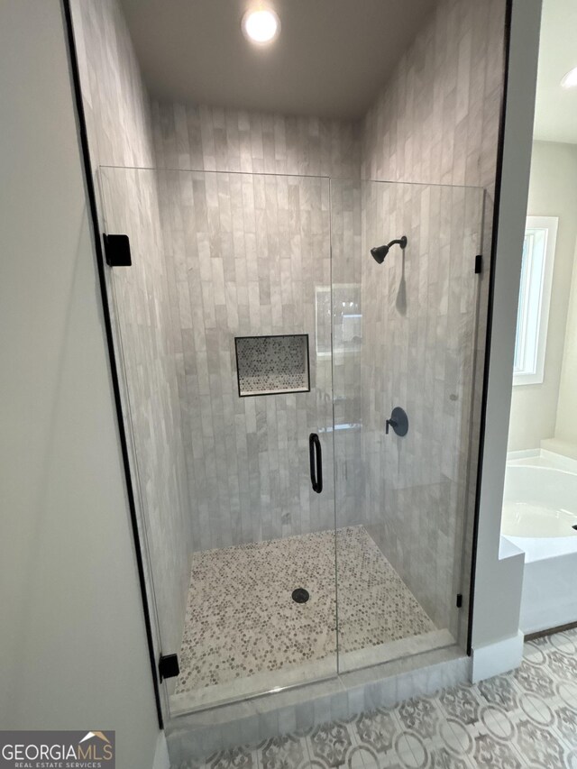 bathroom featuring tile patterned floors and independent shower and bath