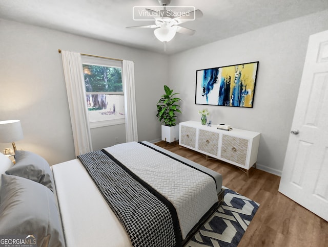 bedroom with wood finished floors, a ceiling fan, and baseboards