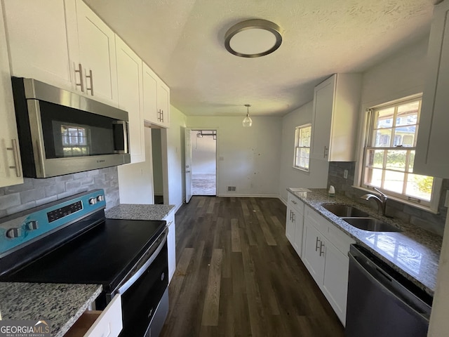 kitchen with backsplash, dark wood-type flooring, white cabinetry, appliances with stainless steel finishes, and sink