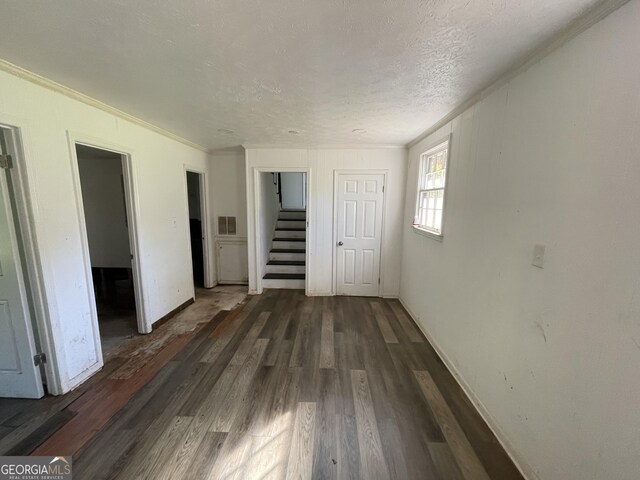 unfurnished bedroom featuring hardwood / wood-style floors, crown molding, and a textured ceiling