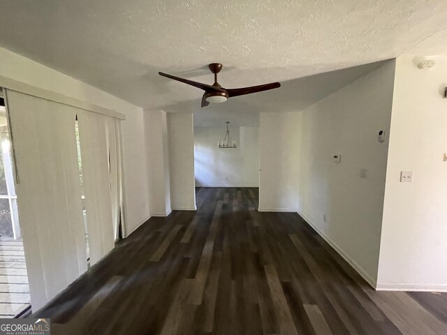 corridor featuring a textured ceiling and dark hardwood / wood-style flooring