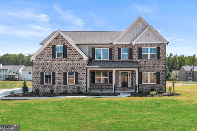 craftsman inspired home with board and batten siding, a front yard, brick siding, and roof with shingles