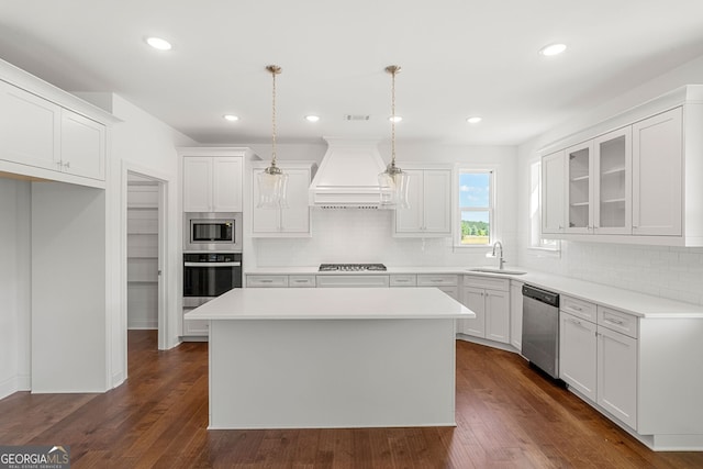 kitchen with stainless steel appliances, light countertops, hanging light fixtures, glass insert cabinets, and premium range hood