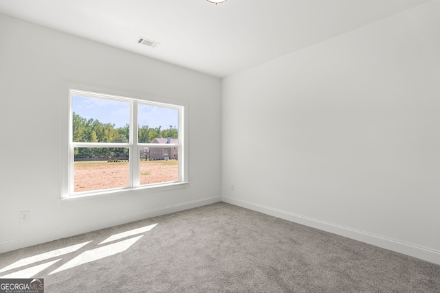 carpeted empty room featuring visible vents and baseboards