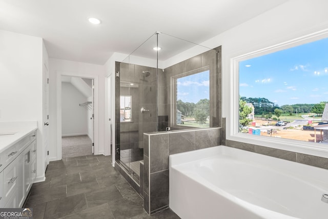 bathroom featuring a garden tub, a spacious closet, vanity, a shower stall, and recessed lighting