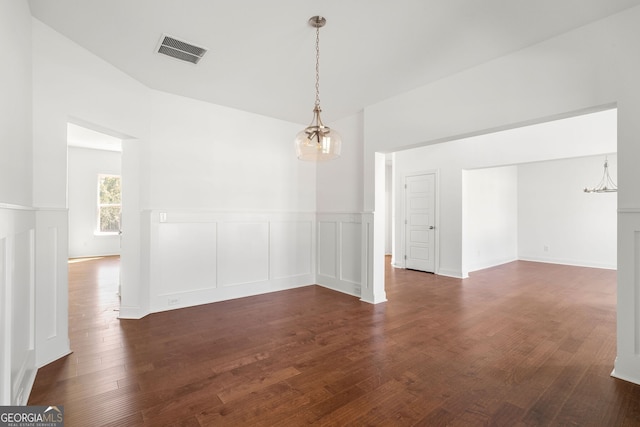 unfurnished dining area with wainscoting, visible vents, dark wood finished floors, and a decorative wall