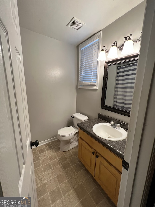 bathroom with vanity, toilet, and tile patterned floors