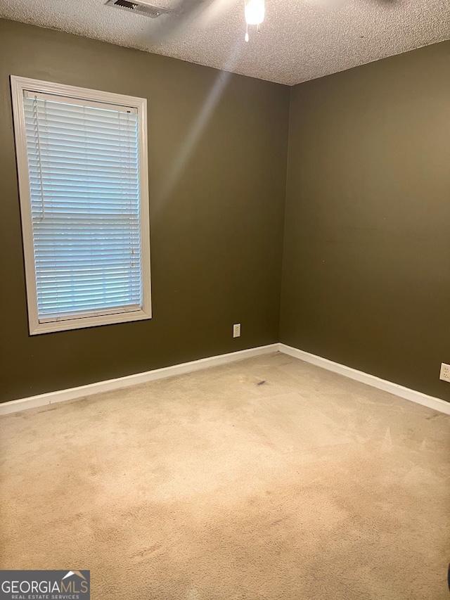 carpeted spare room featuring a textured ceiling