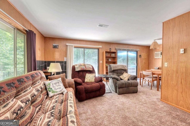 living room featuring carpet, visible vents, an AC wall unit, and wooden walls