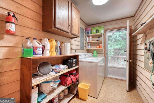 laundry room with wood walls, cabinets, and independent washer and dryer