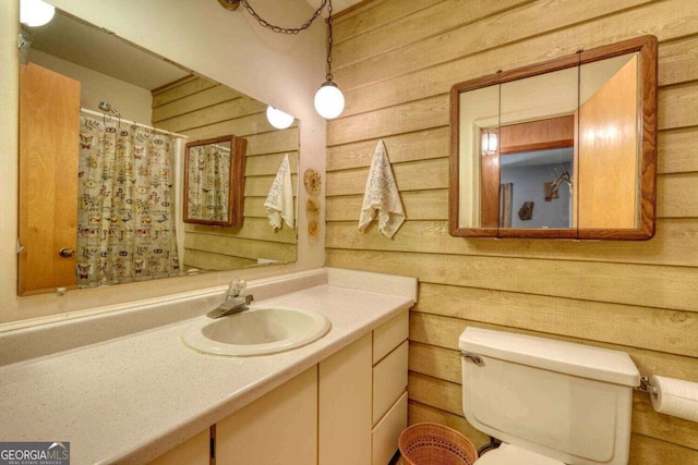 full bathroom with wood walls, toilet, curtained shower, and vanity