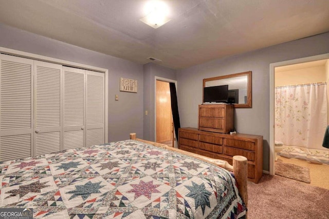 bedroom with a closet, connected bathroom, carpet, and visible vents