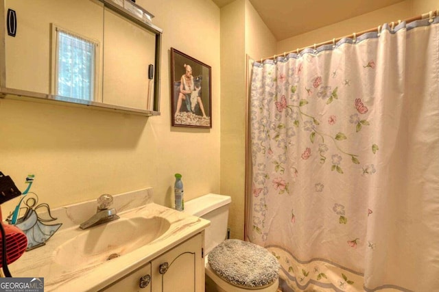 bathroom featuring a shower with shower curtain, toilet, and vanity