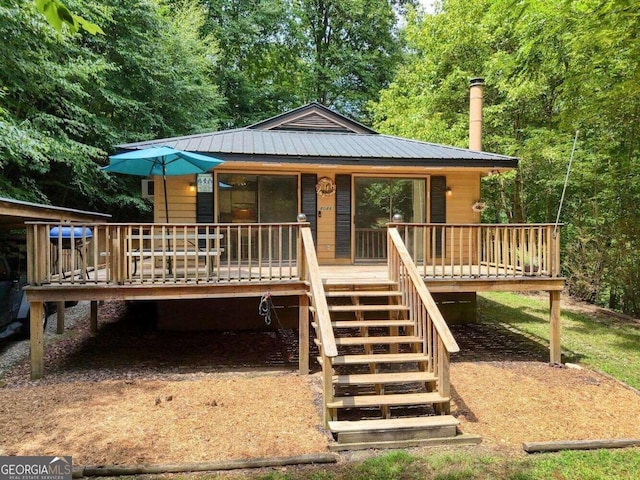 rear view of house featuring metal roof, covered porch, and stairway