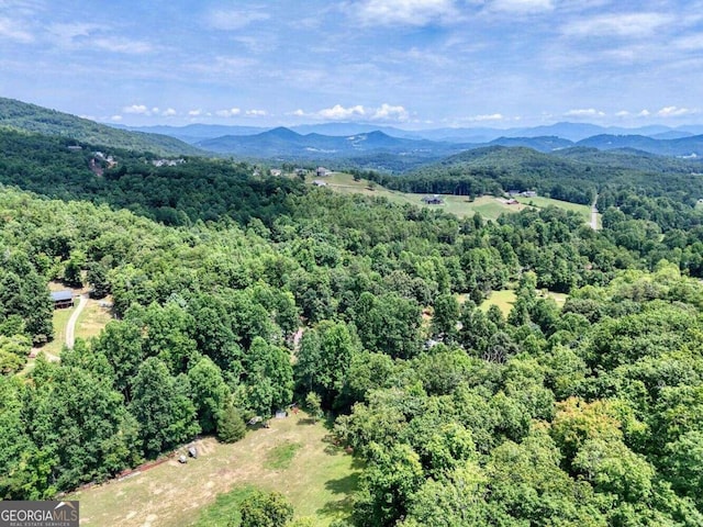 birds eye view of property featuring a wooded view and a mountain view