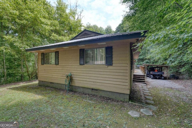 view of side of home with metal roof and crawl space