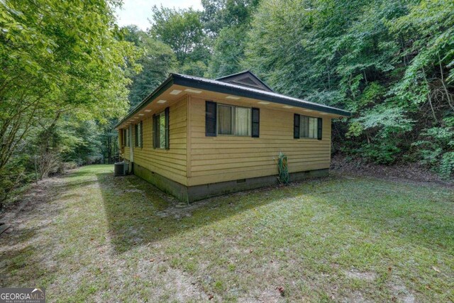 view of property exterior with a yard and central AC unit