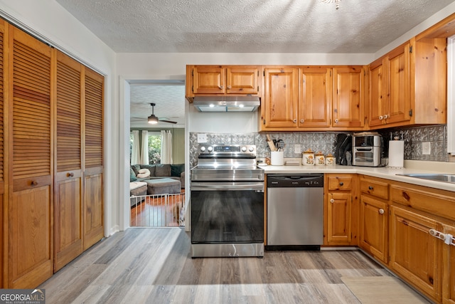 kitchen with backsplash, dishwasher, light hardwood / wood-style floors, range with electric stovetop, and ceiling fan