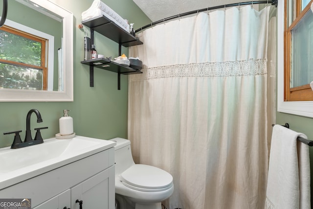 bathroom with a textured ceiling, toilet, and vanity