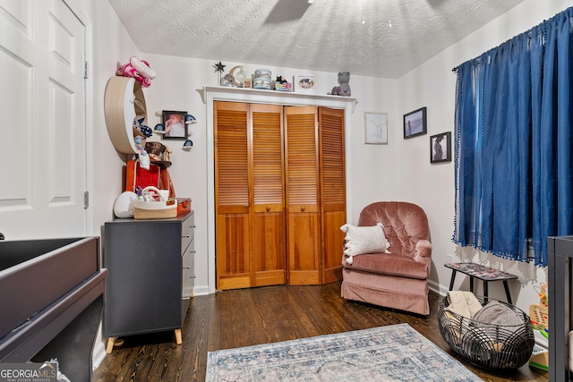 sitting room featuring a textured ceiling and dark hardwood / wood-style floors