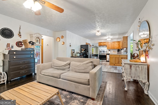 living room featuring ceiling fan, hardwood / wood-style flooring, and a textured ceiling