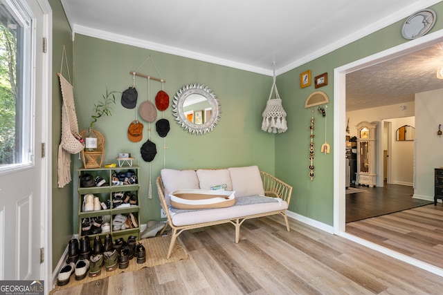 living area featuring a textured ceiling, crown molding, and hardwood / wood-style floors