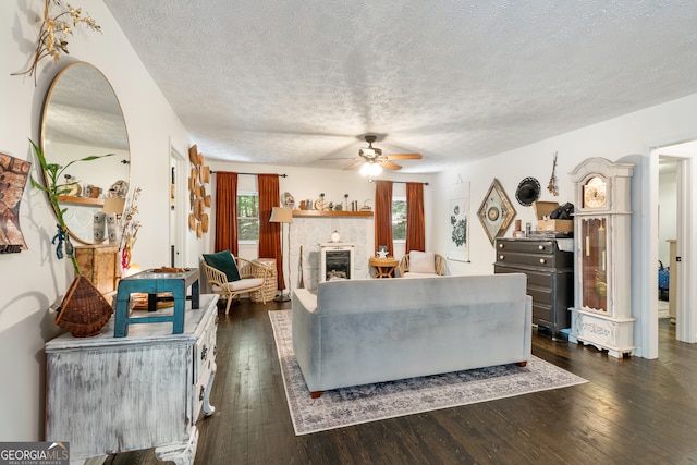 living room featuring dark hardwood / wood-style flooring, plenty of natural light, and a tiled fireplace