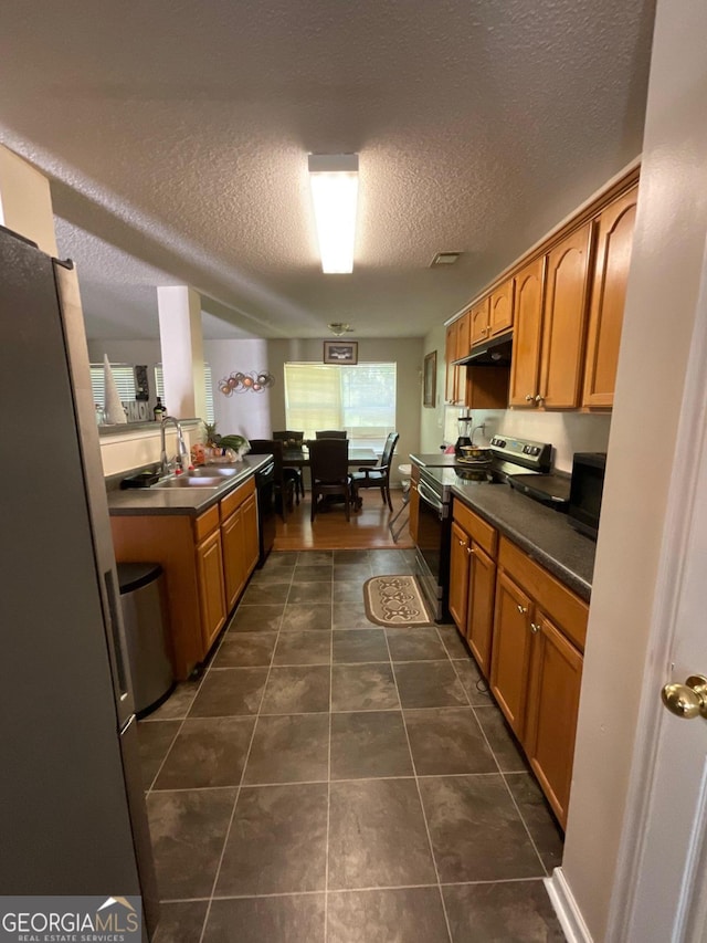 kitchen featuring a textured ceiling, dishwasher, electric range, and dark tile patterned flooring