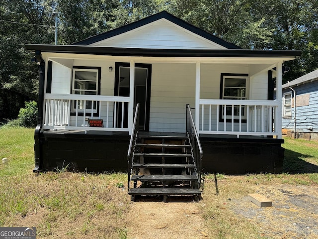 bungalow-style house with a front lawn and covered porch