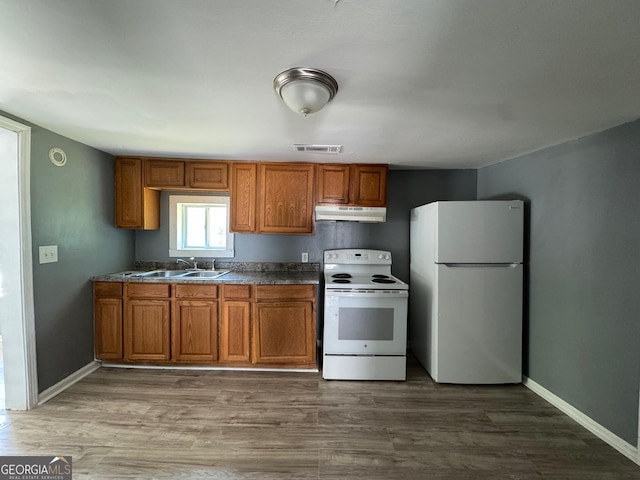 kitchen with white appliances, dark hardwood / wood-style floors, and sink