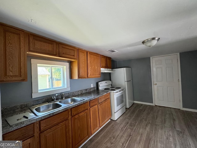 kitchen featuring dark wood-type flooring, white appliances, and sink