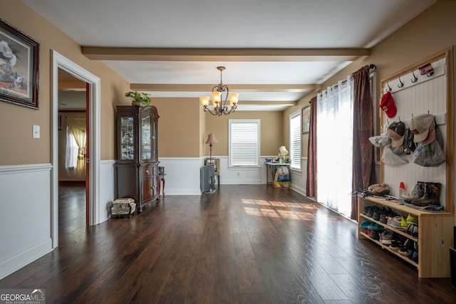 interior space with a notable chandelier, beamed ceiling, and dark hardwood / wood-style flooring