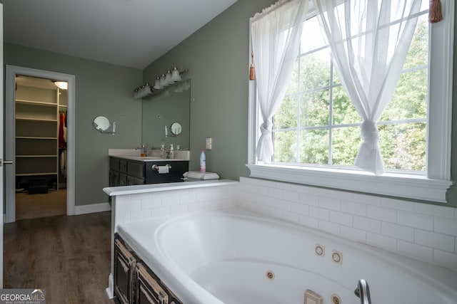 bathroom with vanity, hardwood / wood-style flooring, and a washtub