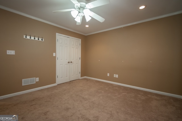 carpeted empty room featuring ceiling fan and ornamental molding