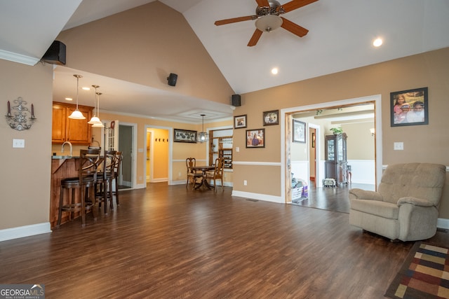 living room featuring crown molding, dark hardwood / wood-style flooring, ceiling fan, sink, and high vaulted ceiling